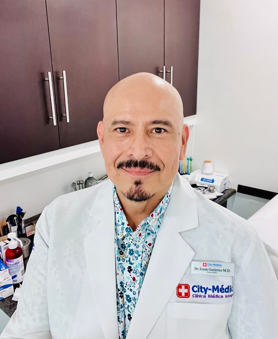 Dr. Essaú Gutiérrez in a City-Médica coat in a consultation room